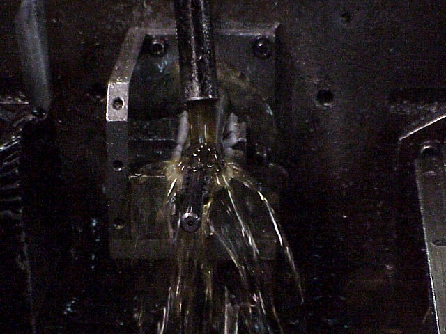 Getting photo's of the action machining steps proved difficult, but here are the few that turned out well.  This photo shows a broach being pulled through the action blank to cut the raceways.