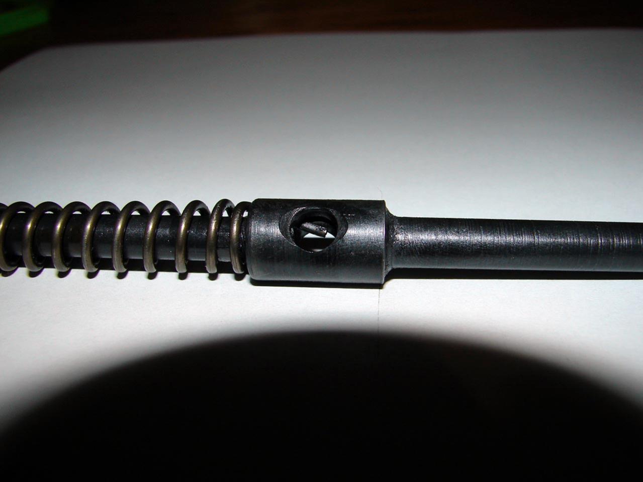This photo shows how the firing pin spring's tail protrudes into the cocking pin slot to retain the cocking piece pin.